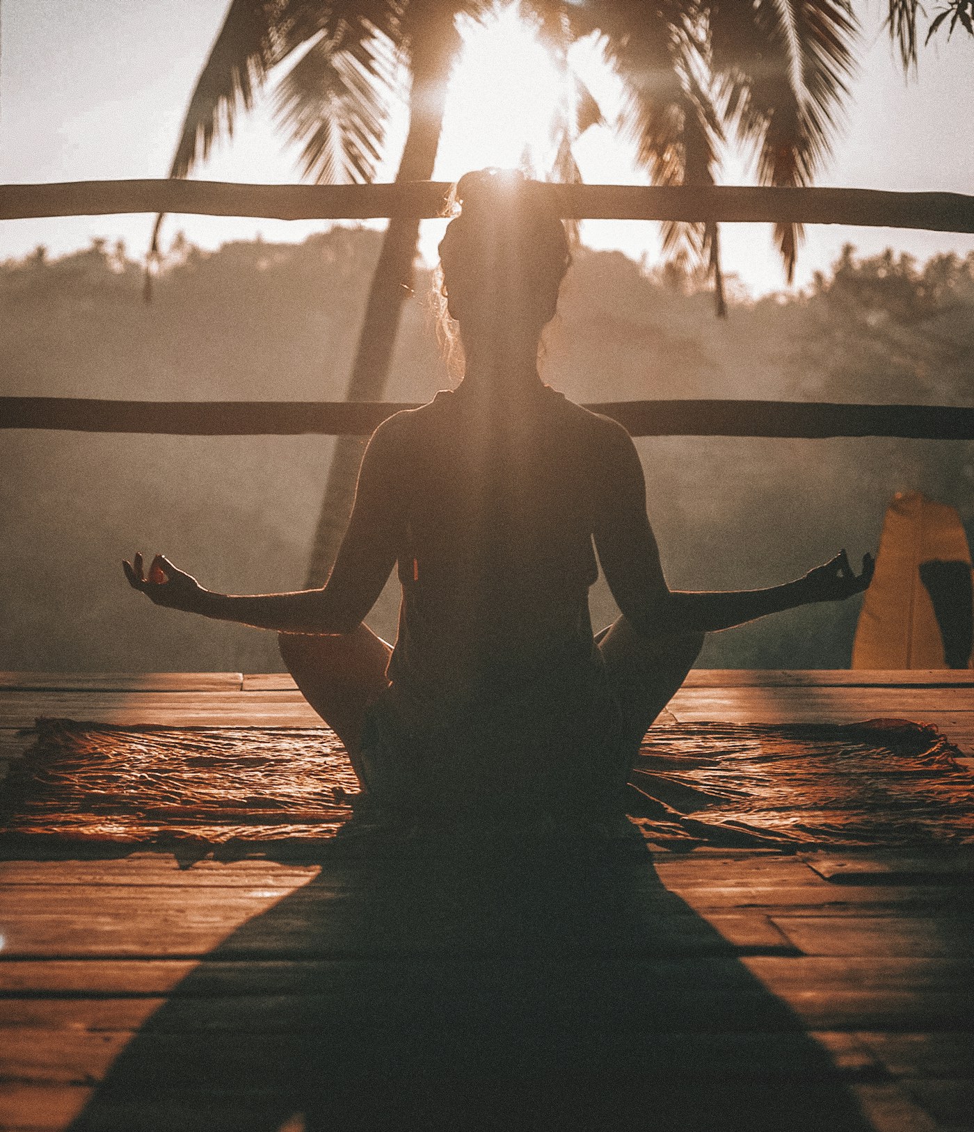 Person meditating outdoors in a calm natural setting